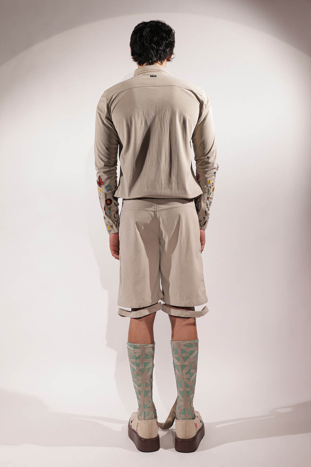 Beige suede shacket with mountain-inspired pockets and floral embroidery