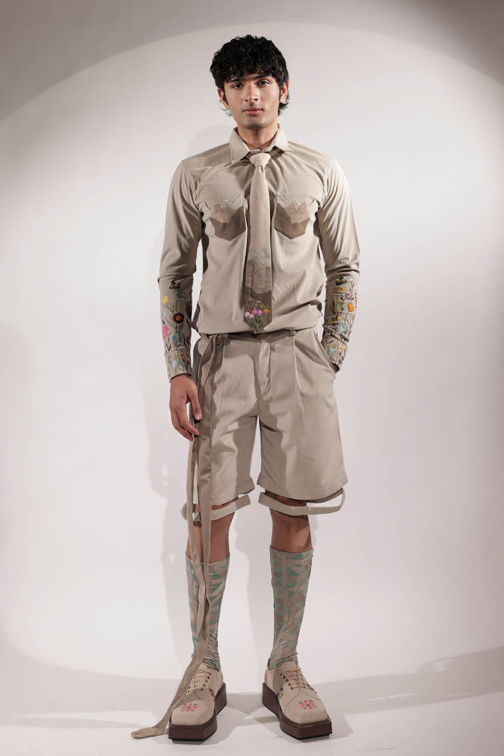 Beige suede shacket with mountain-inspired pockets and floral embroidery