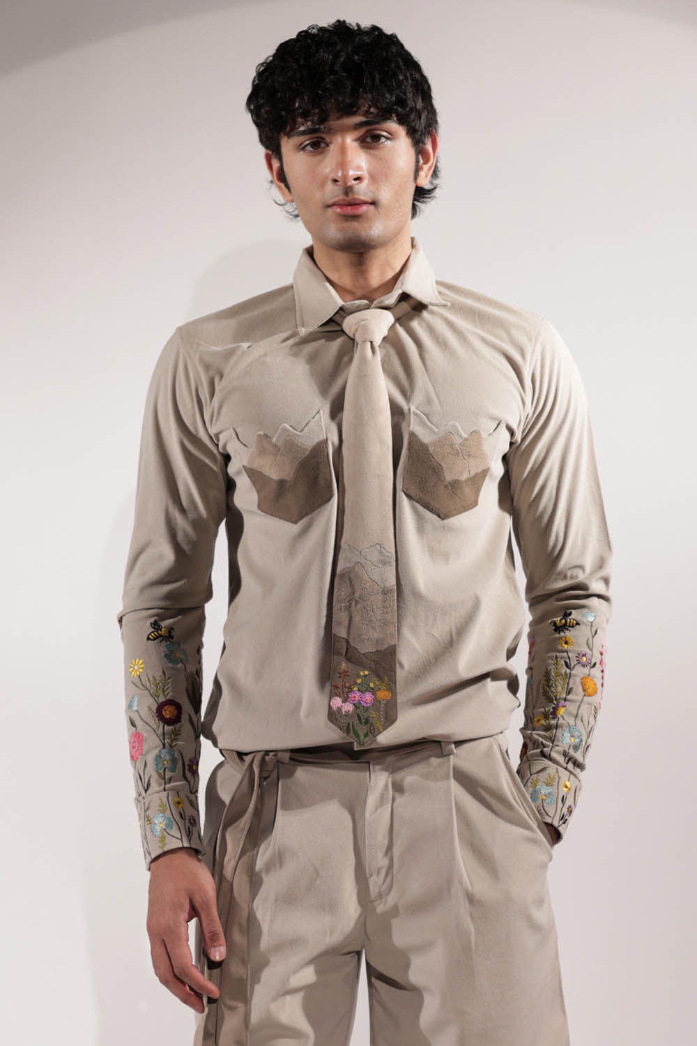 Beige suede shacket with mountain-inspired pockets and floral embroidery