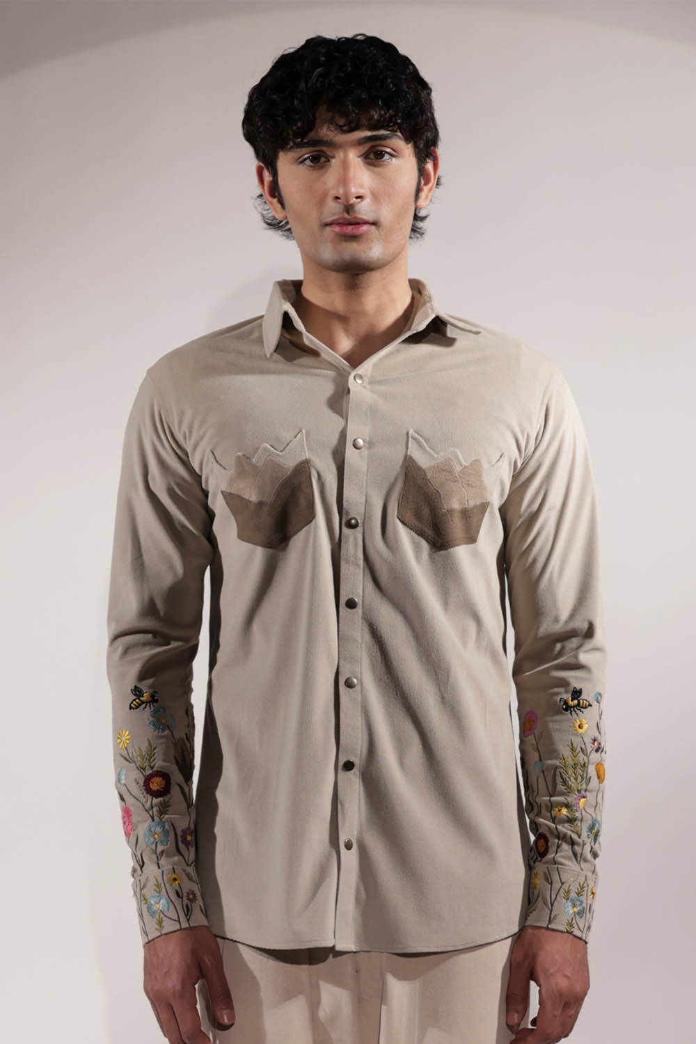 Beige suede shacket with mountain-inspired pockets and floral embroidery